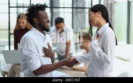 Welcome to our team Shaking hands while working in the creative office Stock Photo