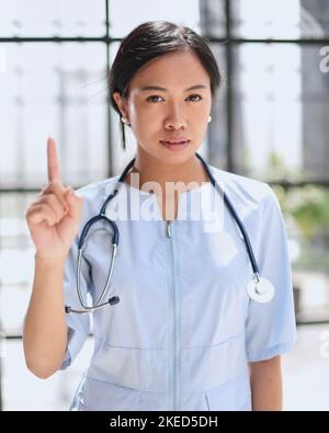 Portrait of asian female doctor showing thumbs up and smiling Stock Photo