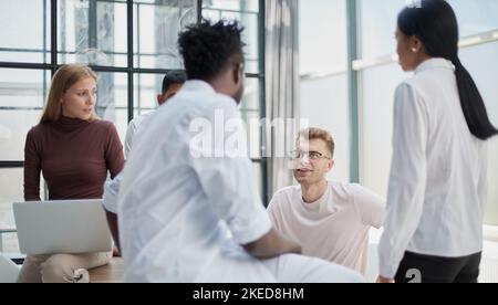 Busy day. Group of multiracial business people working together in the creative co-working space Stock Photo