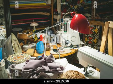 Tailor's workplace. Fabrics on wooden shelves. Sewing machines. Stock Photo