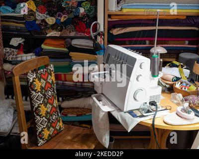 Tailor's workplace. Fabrics on wooden shelves. Sewing machines. Stock Photo