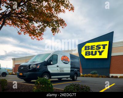 New Hartford, New York - Oct 19, 2022: Landscape Wide View of Geek Squad Black and White Van in Foreground and Best Buy Building in Background. Stock Photo