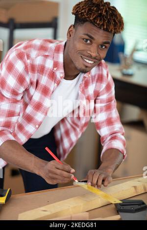 young male carpenter working with wood in his workshop Stock Photo