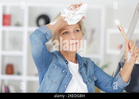 senior tired woman restingfrom painting her home Stock Photo