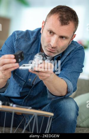 man holds small action camera selective focus Stock Photo