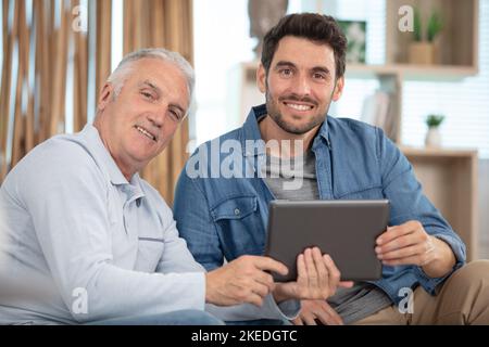 senior father and young son with tablet Stock Photo