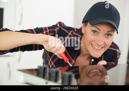 woman installing induction hobs in kitchen Stock Photo