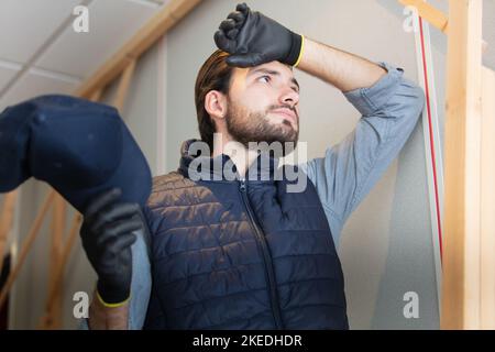 young builder is tired of working Stock Photo