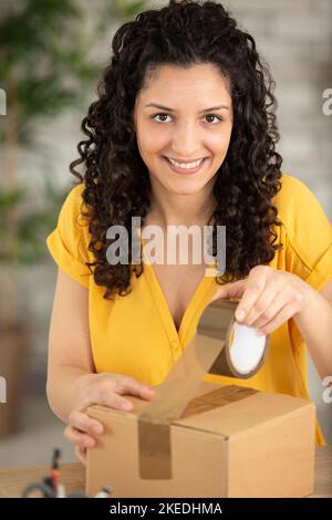excited young woman packing package Stock Photo