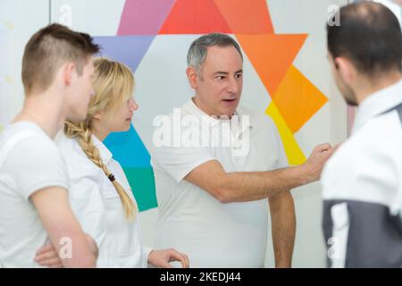 portrait of painter teaching apprentices Stock Photo