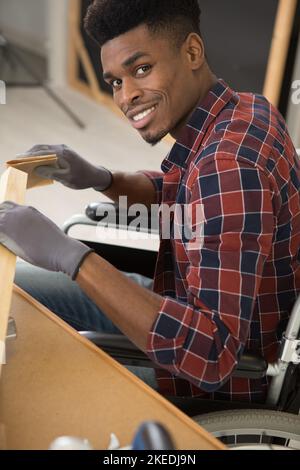 disabled worker in wheelchair in a carpenters workshop Stock Photo