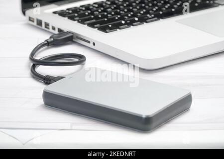 working at office, laptop on the table connected USB Cable with External Hard Drive Stock Photo