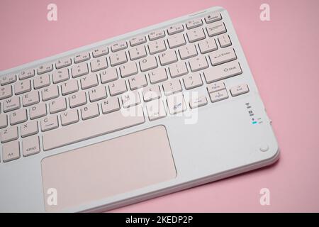 working with wireless external portable keyboard isolated pink background Stock Photo