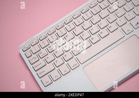 working with wireless external portable keyboard isolated pink background Stock Photo