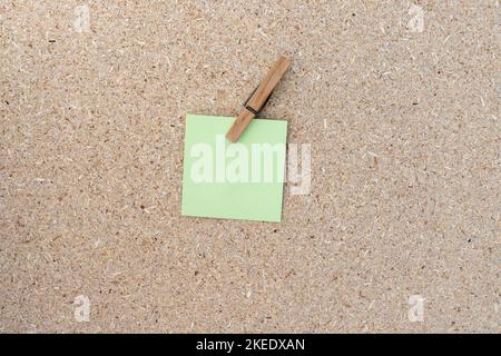 Blank sticky notes clip with a clothespin on a cork board background Stock Photo