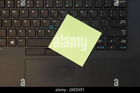 Yellow blank sticky note over a laptop keyboard high angle view Stock Photo