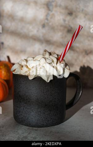 pumpkin cinnamon spice latte on grey marble table, pumpkins in background  Stock Photo