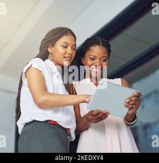 Managing their business the modern way. young business partners working on a digital tablet together. Stock Photo