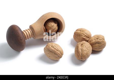 Walnuts and wooden nutcracker on a white background close-up Stock Photo