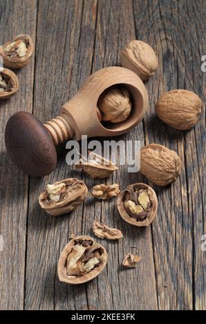 Nutcracker and walnuts on old wooden background close-up Stock Photo