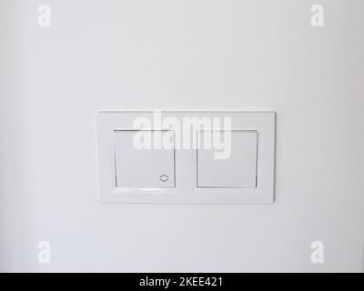 Double white plastic mechanical switches, installed on a white wall Stock Photo