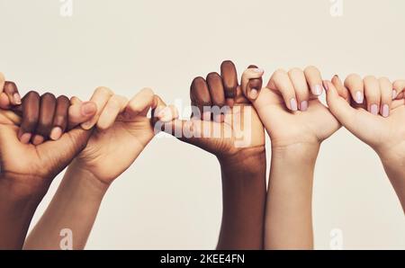 Were stronger together. a group of unrecognizable people holding one anothers thumbs in a single line. Stock Photo