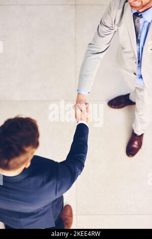 Well be doing great things together. High angle shot of two businessmen shaking hands in an office. Stock Photo