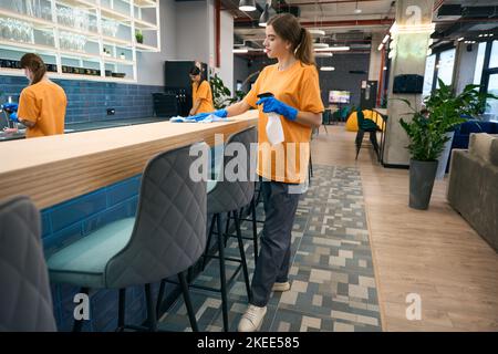 Teamwork of cleaners in coworking, women clean with good mood Stock Photo