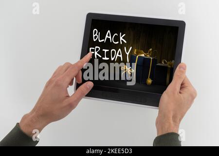 man using tablet pc and selecting black friday. Stock Photo