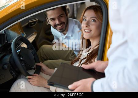 Automotive dealership clients communicating with auto sales representative Stock Photo