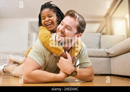 Family, children and fun with a foster father and girl having fun together on the living room floor of their home together. Love, smile and happy with Stock Photo