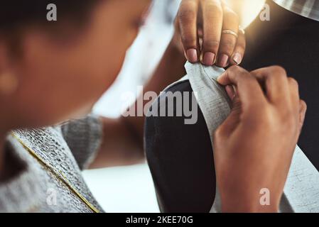 Every stitch is important. a young fashion designer working on a mannequin in her workshop. Stock Photo