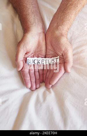 Whats on your bucket list. a person holding a piece of paper with the words bucket list written on it. Stock Photo