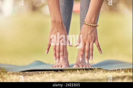 Hands, yoga and stretching with a sports woman practicing meditation on a field outdoor in summer. Fitness, peace and wellness with a female athlete Stock Photo