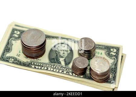 Pile of American dollars cash money banknote papers of different values with stacks of American coins of 1 dollar, 50 cents, quarters, 10 cents dime, Stock Photo