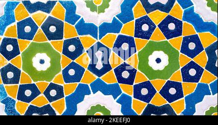 Vintage oriental colored tiles on the wall. Old geometric pattern as building decoration Stock Photo