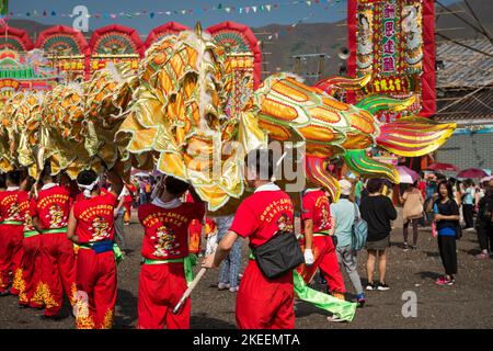 Dragon dance team members carry the body and tail of the huge puppet at the decennial Da Jiu festival site, Kam Tin, Hong Kong, 2015 Stock Photo