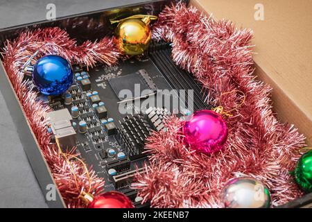 Computer motherboard in a bright gift box with Christmas decorations Stock Photo