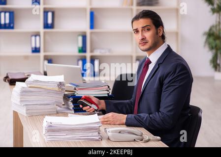 Young businessman employee unhappy with excessive work Stock Photo