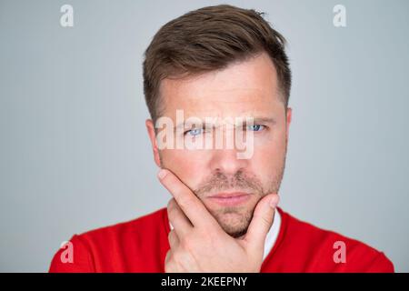 Portrait of pensive mature man touching chin making decision.  Stock Photo