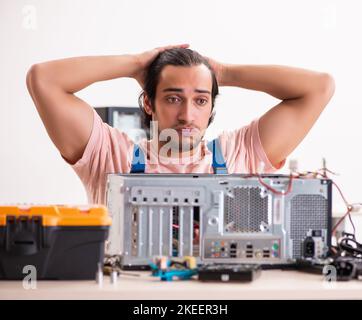 Young male contractor repairing computer Stock Photo