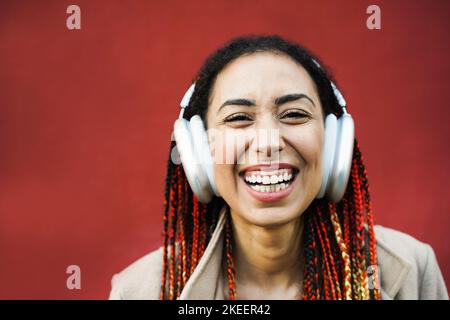Mixed race girl listen playlist music with headphones outdoor - Focus on face Stock Photo