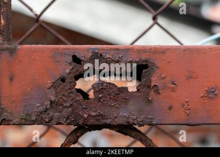 Rusty metal fencing partially destroyed by corrosion. Stock Photo