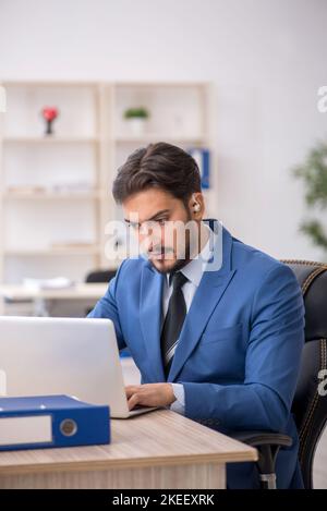 Deaf businessman employee using hearing aid in the office Stock Photo
