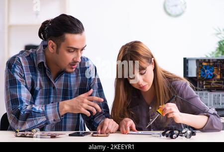 The two technicians working at computer warranty center Stock Photo