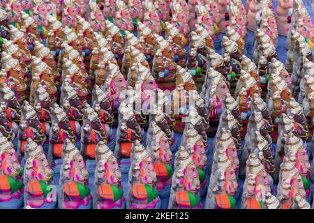 painted vinayagar idols are sequency show case on roadside street selling shop Stock Photo