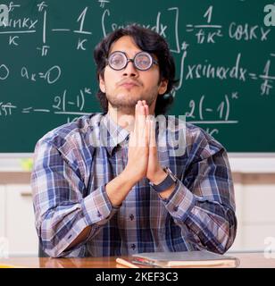 The funny male math teacher in the classroom Stock Photo