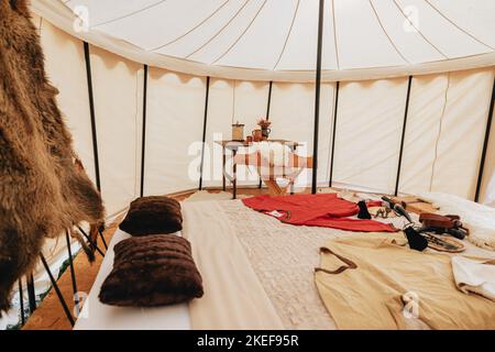 Hunten Robe The interior of a rustic-style tent with hunting equipment and ...