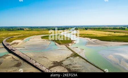 Stunning aerial view of the road and the colourful sand flats surrounding Le Mont Saint Michel during low tide, Normandy, Northern France
