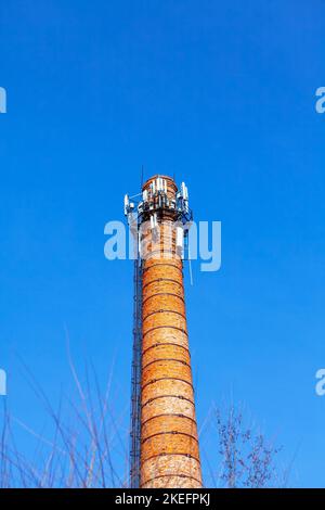 Factory pipe made by bricks . Industrial pipe with antennas Stock Photo